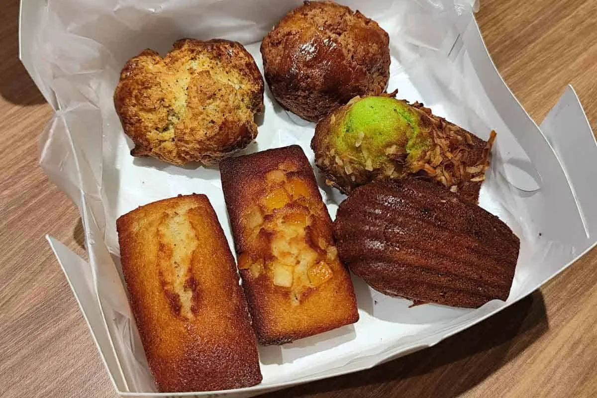 An open My aunty&rsquo;s bakery box holding six bakes &mdash; scones, madeleines and financiers