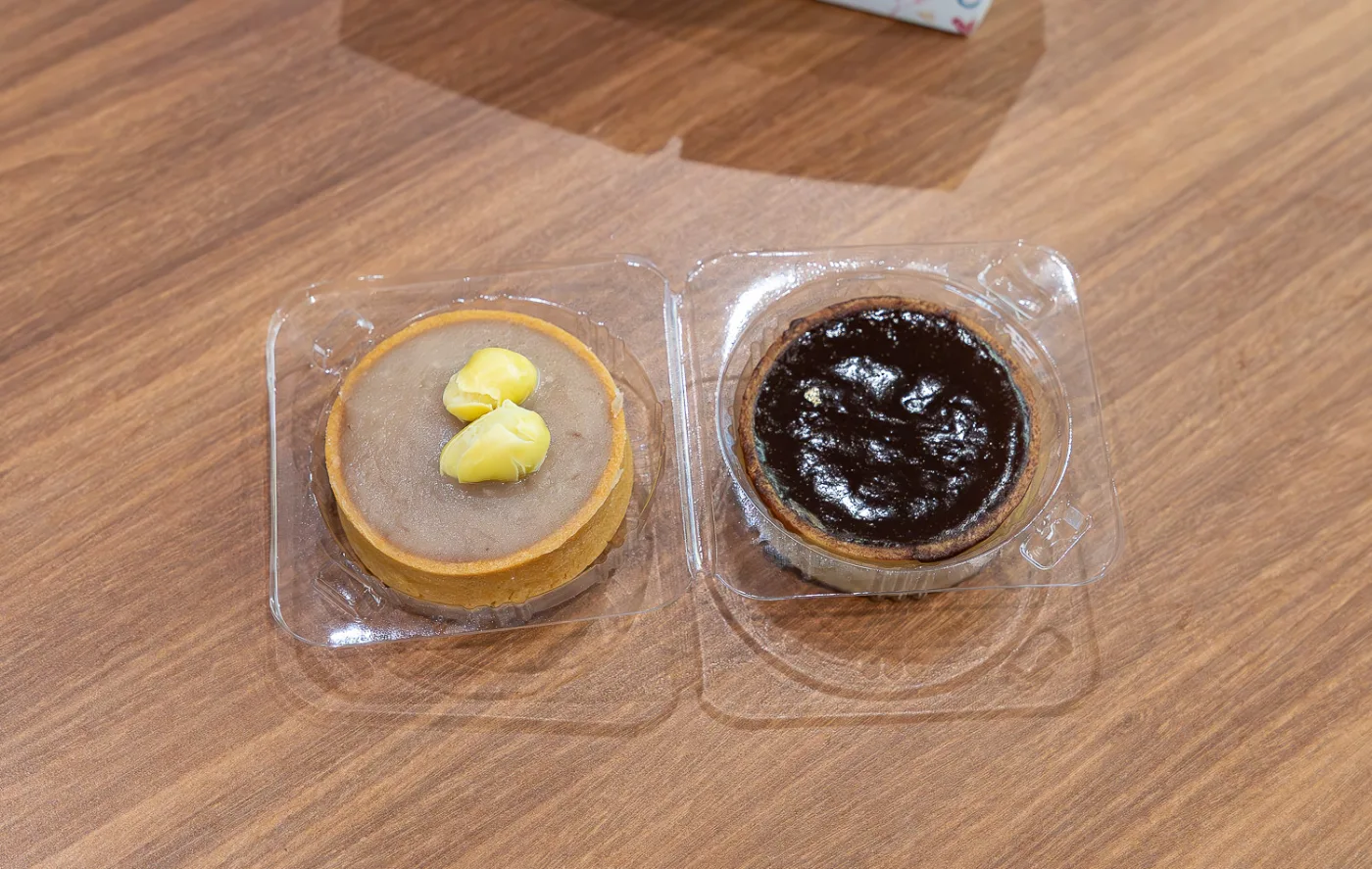My aunty&rsquo;s bakery orh nee tart topped with two gingko nuts, next to a baked chocolate tart